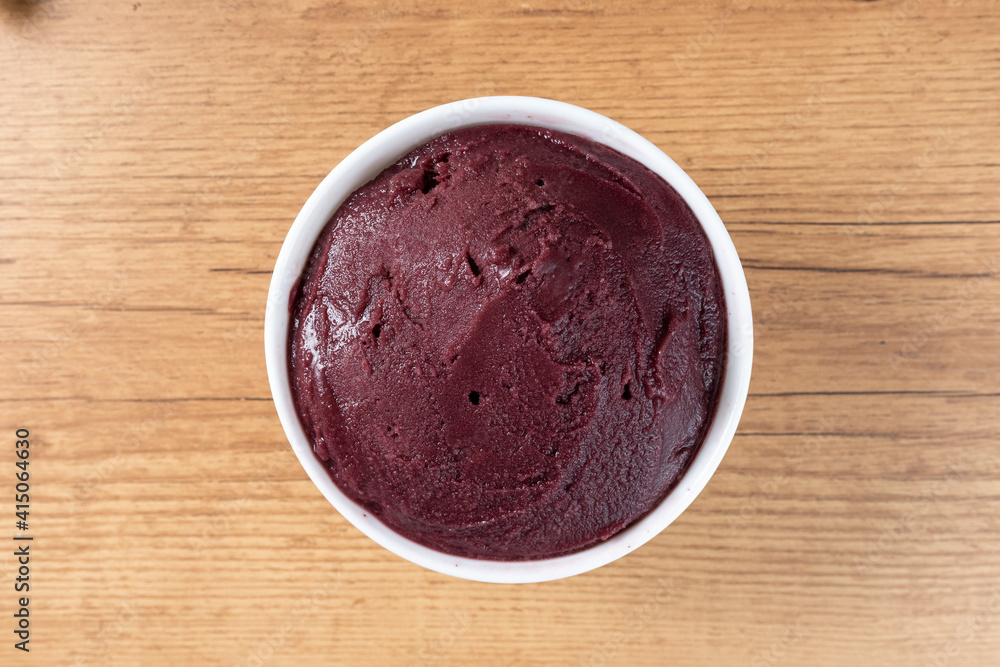 Brazilian frozen açai berry ice cream bowl. with fruits on wooden background. Summer menu top view Brazilian frozen açai berry ice cream bowl. with fruits on wooden background. Summer menu top view