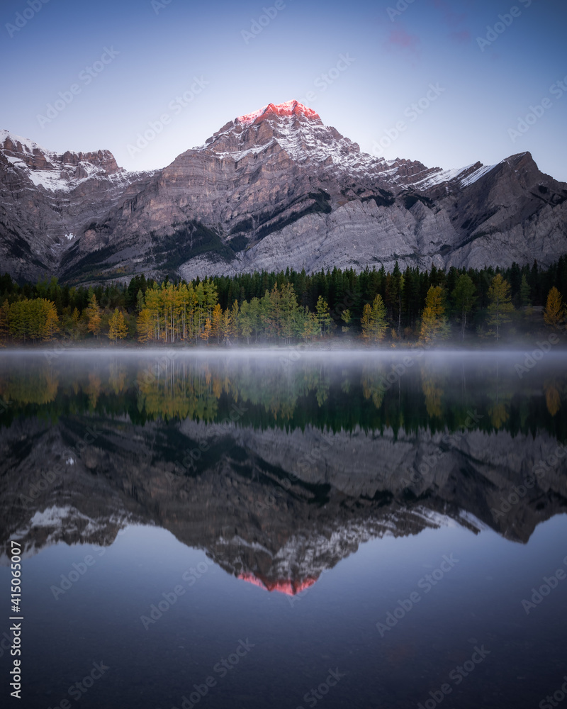 Obraz premium Early morning pink light hitting the summit of Mount Kidd on a cold, frosty morning in Kananaskis Country.