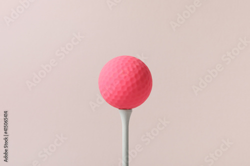 a golf ball of various colors with a pink background