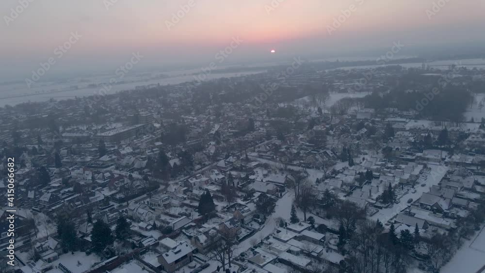 Aerial of beautiful small town covered in snow at dawn Aerial of beautiful small town covered in snow at dawn