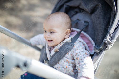 Adorable and happy baby in a stroller with blurry background © Christian