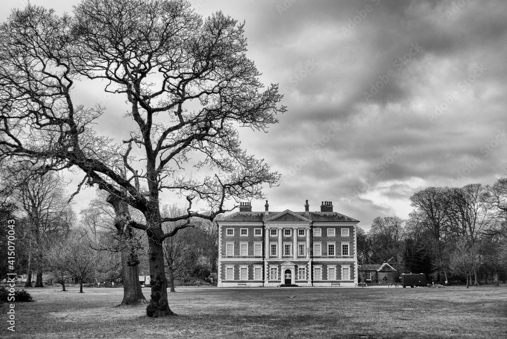Lytham Hall grade 1 country house with tree, grounds and clouds in black and white
