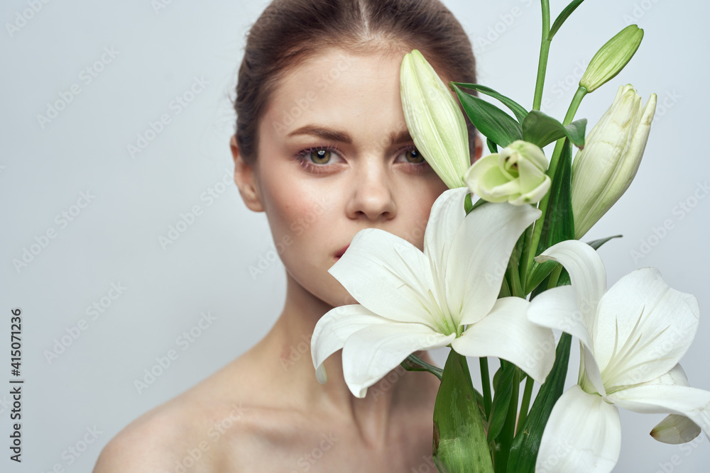 Lady with a bouquet of white flowers on a gray background portrait cropped view close-up Lady with a bouquet of white flowers on a gray background portrait cropped view close-up