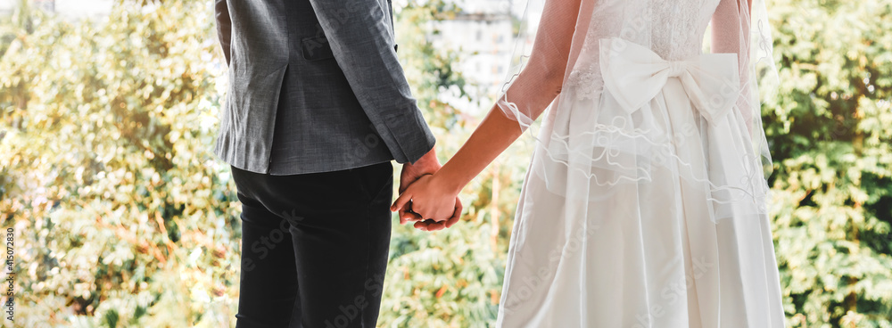 Bride and groom standing and hand in hand in the garden, love and valantine day concept. Bride and groom standing and hand in hand in the garden, love and valantine day concept.