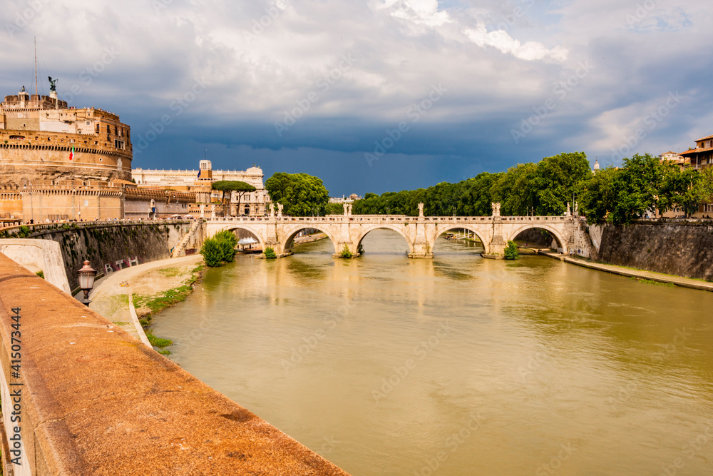 Italy, Rome. Tiber River, Castel Sant'Angelo, tourists on promenade called Lungotevere Vaticano, Ponte Sant'Angelo.