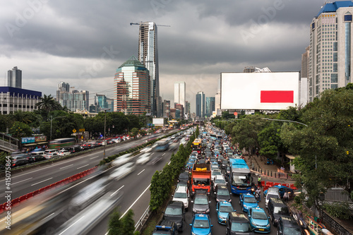 Many cars and motorcyles are stuck in a traffic jam in a very crowded road in Jakarta, Indonesia capital city, caputred with blurred motion photo