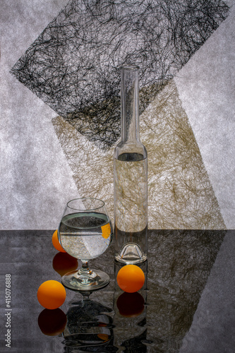 Still life with glassware and orange balls