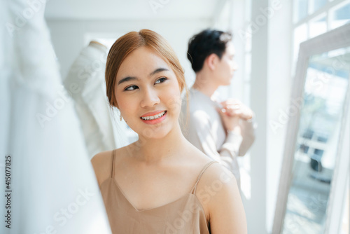Smiling woman among wedding dress.