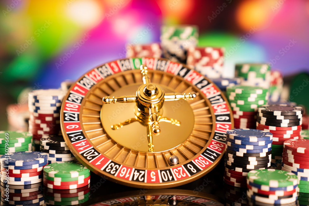 Casino theme. Gambling games. Roulette, dice and poker chips on a colorful bokeh background. Casino theme. Gambling games. Roulette, dice and poker chips on a colorful bokeh background.