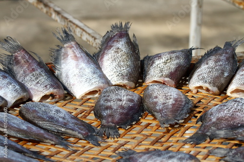 Dried sun gourami fish is dried and on a bamboo