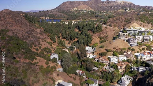 Aerial reverse pull-back shot above the Hollywood Hills with Lake Hollywood in the background. 1080p at 60 FPS.