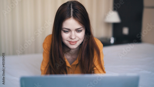 woman with laptop lies in bed sleeping room rest communication