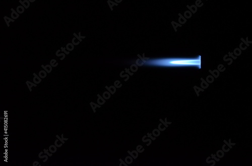 blue gas jet flame on black background