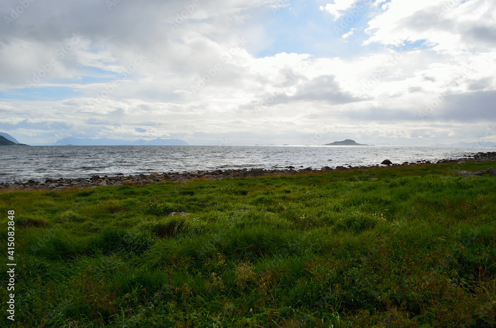 green sea shore with mighty mountain and open sea background