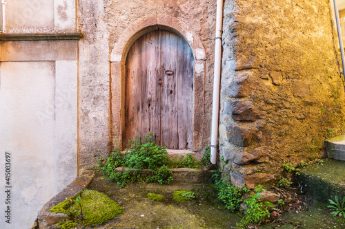 Italy, Sicily, Province of Messina, Novara di Sicilia. A weathered arched door in the medieval hill town of Novara di Sicilia.
