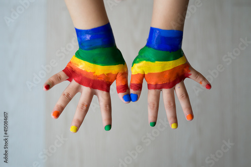 Colourful rainbow, toddler small child's painted hand up on the white background