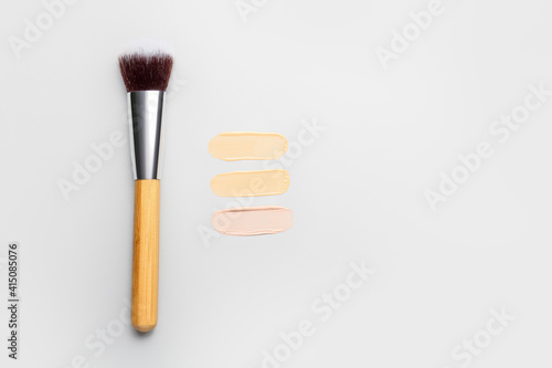Samples of makeup foundation and brush on light background