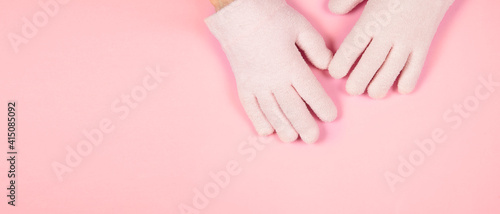 Banner with spa gel moisturizing gloves on pink background with copy space for design. Skin care and beauty routine concept. © Marina
