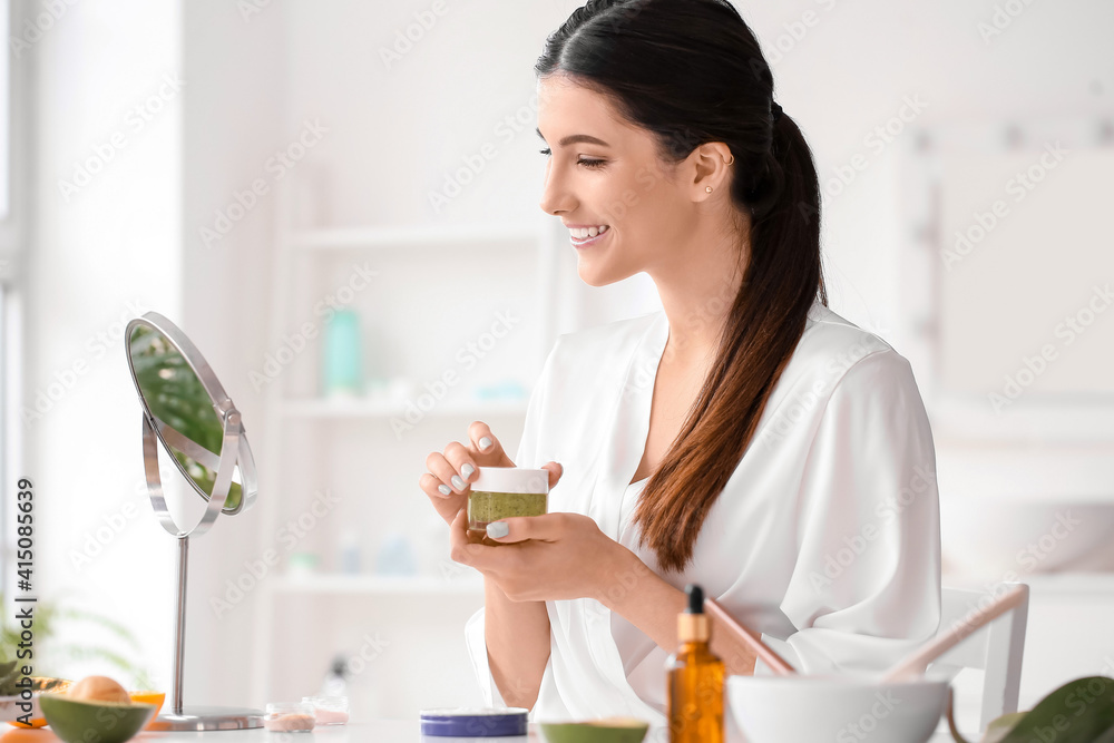 Beautiful young woman with cosmetic products in bathroom Beautiful young woman with cosmetic products in bathroom