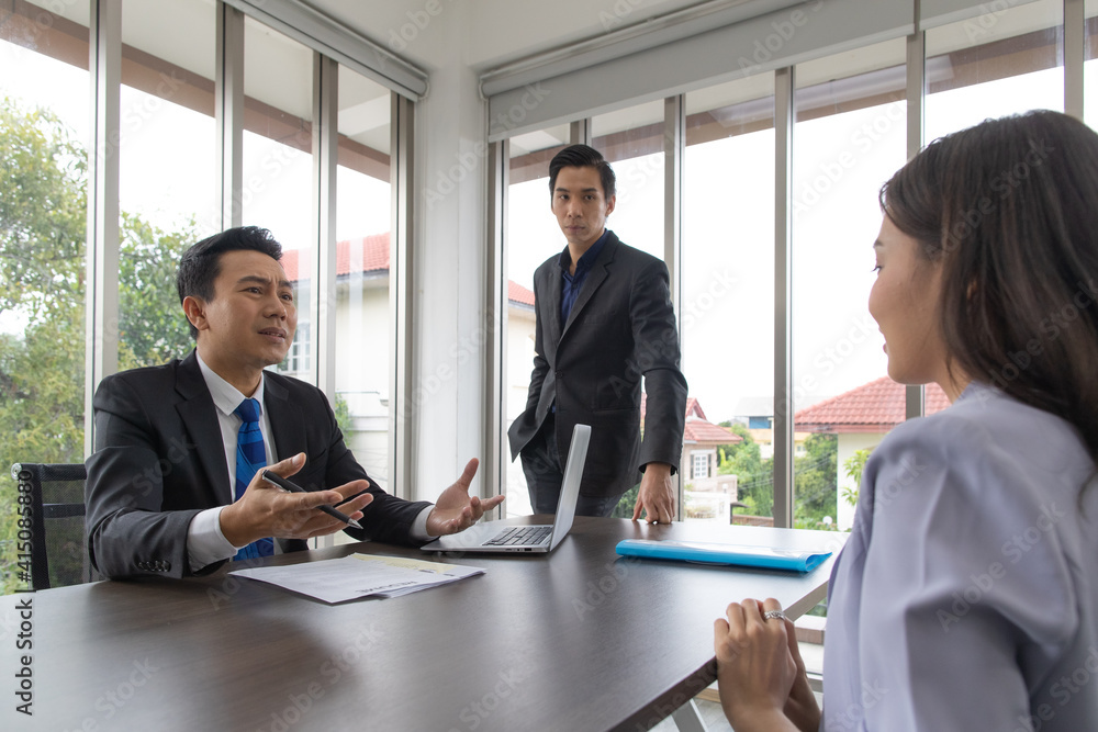 Human Resources Manager And male supervisors Checking the young woman job resume with a serious expression. Human Resources Manager And male supervisors Checking the young woman job resume with a serious expression.
