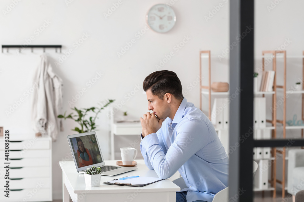 Psychologist working with patient online while sitting in office