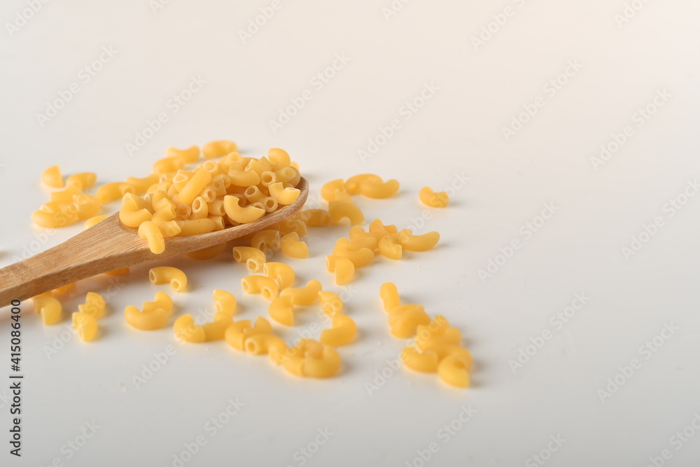 uncooked elbow macaroni on a white background.
uncooked elbow macaroni on a white background.