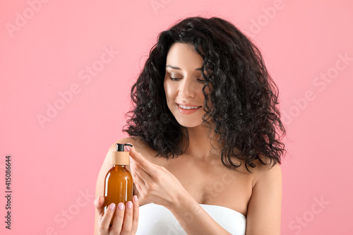 Foto Beautiful young woman with cosmetic product on color background
