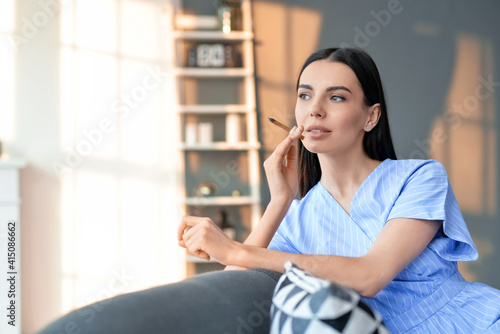 Young woman smoking cigarette at home