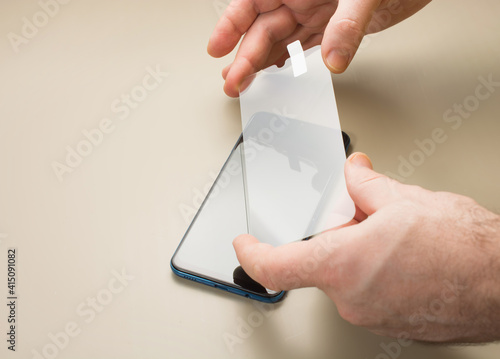 Εκτύπωση καμβά top view of installation of protective cover film on the smartphone