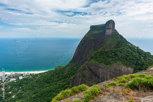Beautiful scene from up Pedra Bonita overlooking Pedra da Gávea and São Conrado beach, emerald sea and lush vegetation.