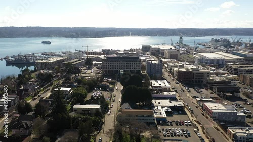 Cinematic drone clip of Bremerton, Manette, Sinclair Inlet, Puget Sound Naval Shipyard, the downtown marina, ferry terminal and shops in the background in Kitsap County, Washington State photo