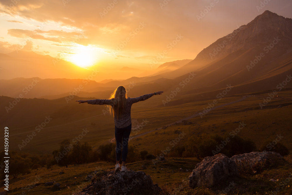 Blonde model at the sunset in mountains 