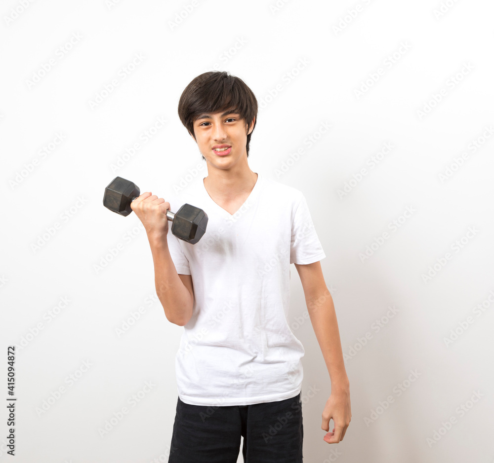 Young teenage boy exercising with dumbbells isolated against a white background. Young teenage boy exercising with dumbbells isolated against a white background.