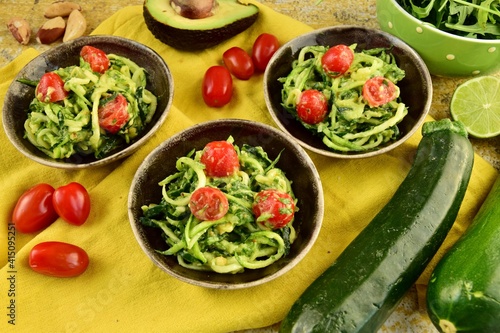Zucchini noodle with avocado sauce, arugula and cherry tomatoes