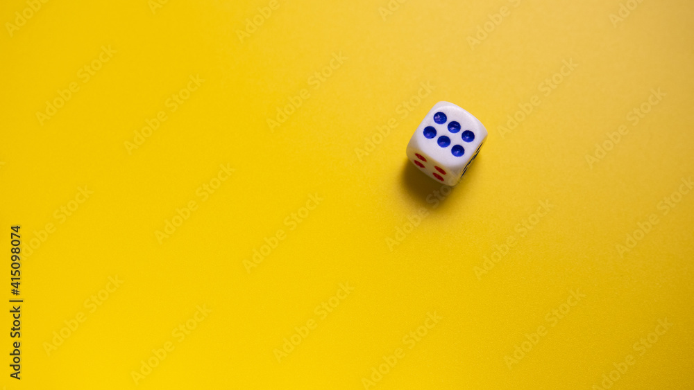 White dice with round dots number six on yellow background close-up. Concept of gambling and chance White dice with round dots number six on yellow background close-up. Concept of gambling and chance
