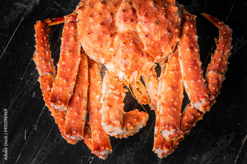 Tasty king kamchatka crab on wood board at brown background