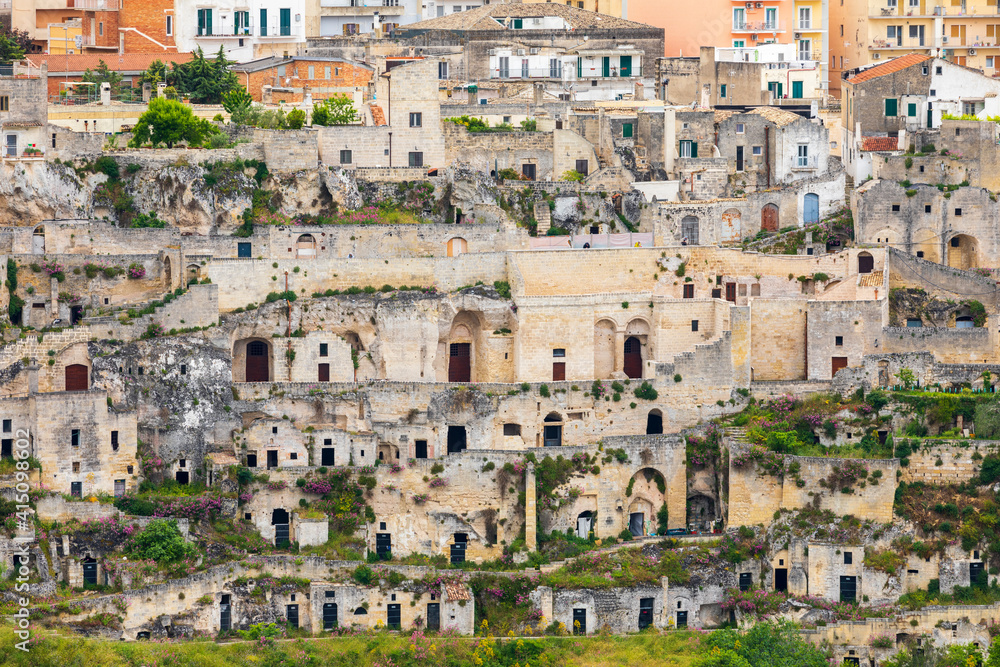 Italy, Basilicata, Province of Matera, Matera. City of Matera seen from across the valley of the Torrente Gravina (Gravina river). Shows the Sassi, dwellings carved out of the stone of the cliff.