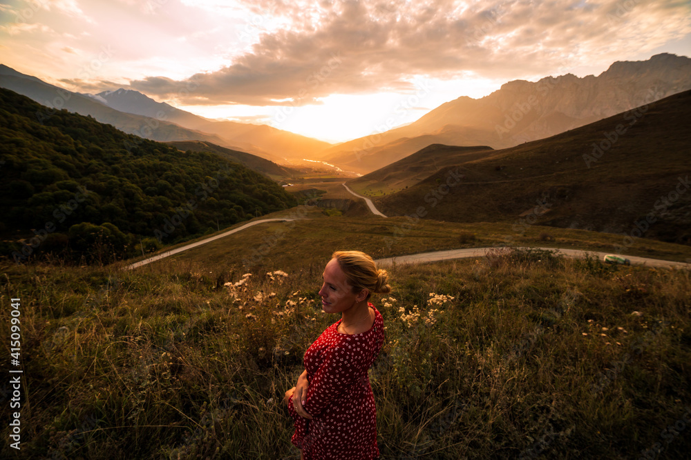 Blonde model at the sunset in mountains