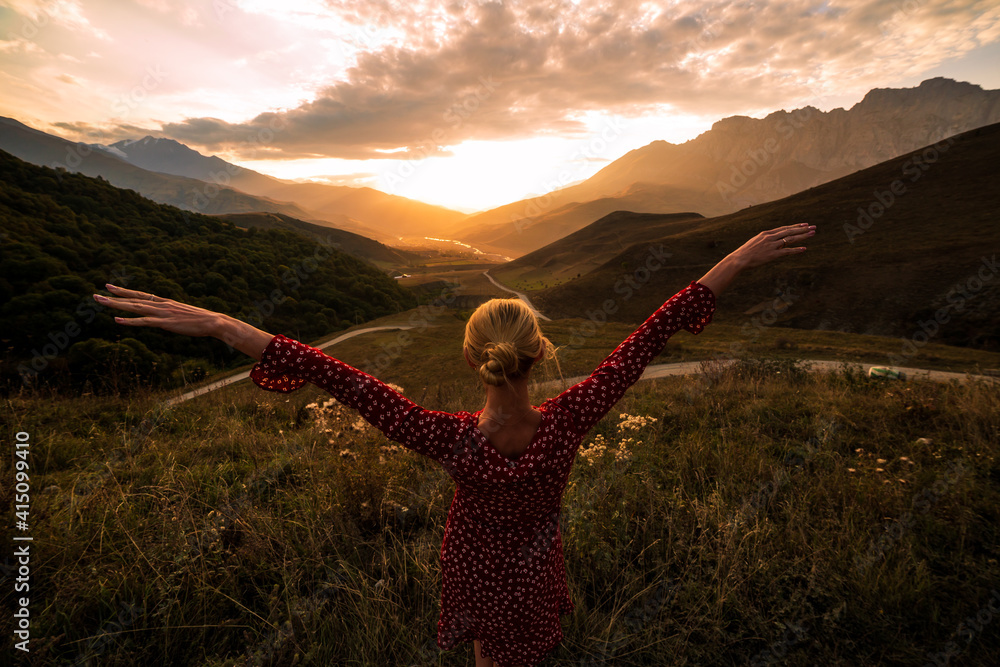 Blonde model at the sunset in mountains