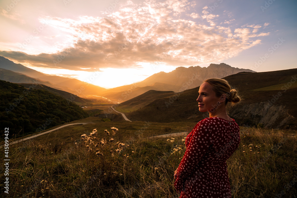 Blonde model at the sunset in mountains