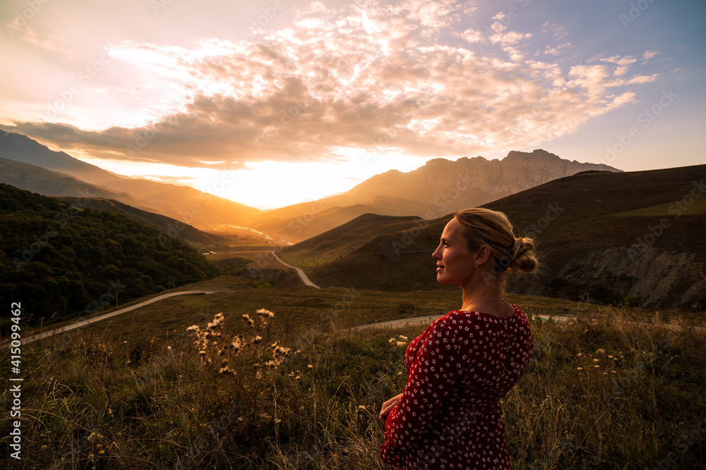 Blonde model at the sunset in mountains