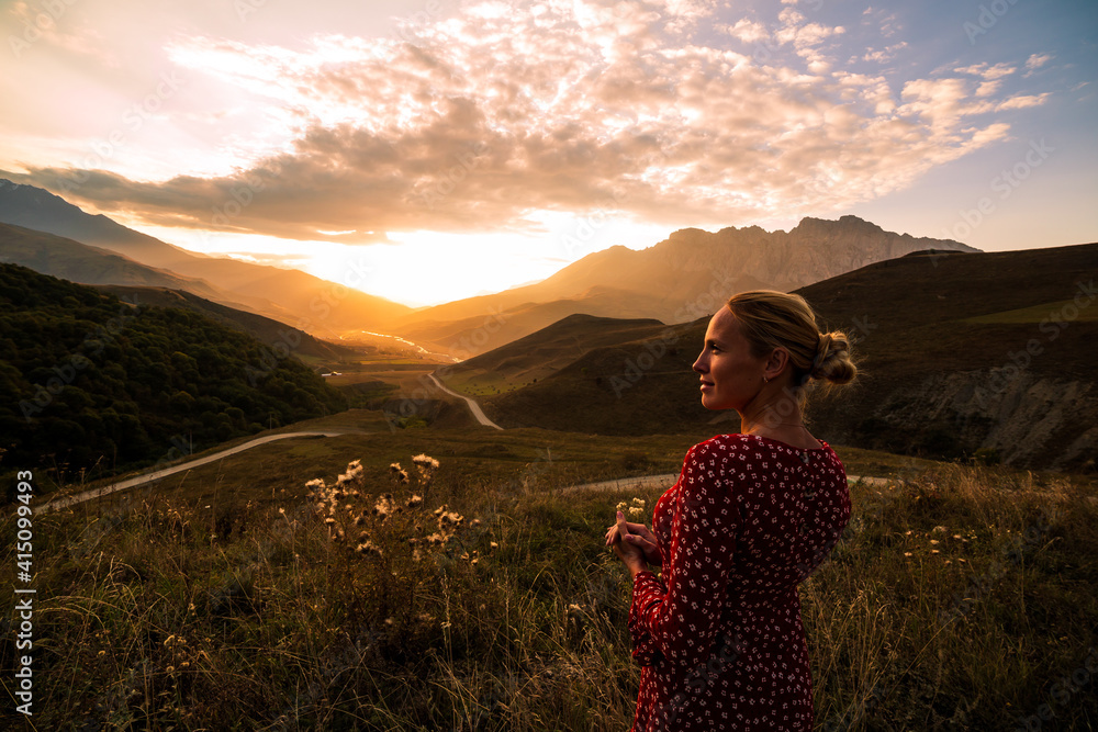 Blonde model at the sunset in mountains