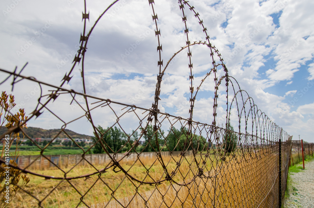 Close up view of barbed wire on the fence. Protection of the property. Protective fence. Close up view of barbed wire on the fence. Protection of the property. Protective fence.