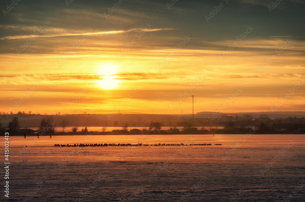 Naklejka premium Romantischer Sonnenuntergang über dem zugefrorenen Süßen See mit Blick auf Aseleben