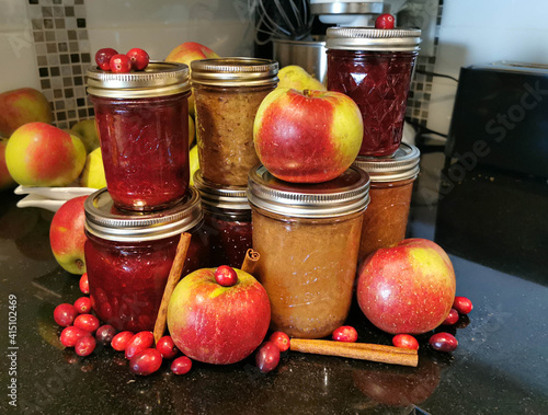 Apple Cranberry Sauce Fruit with Cinnamon  sticks and jars of sauce in kitchen
