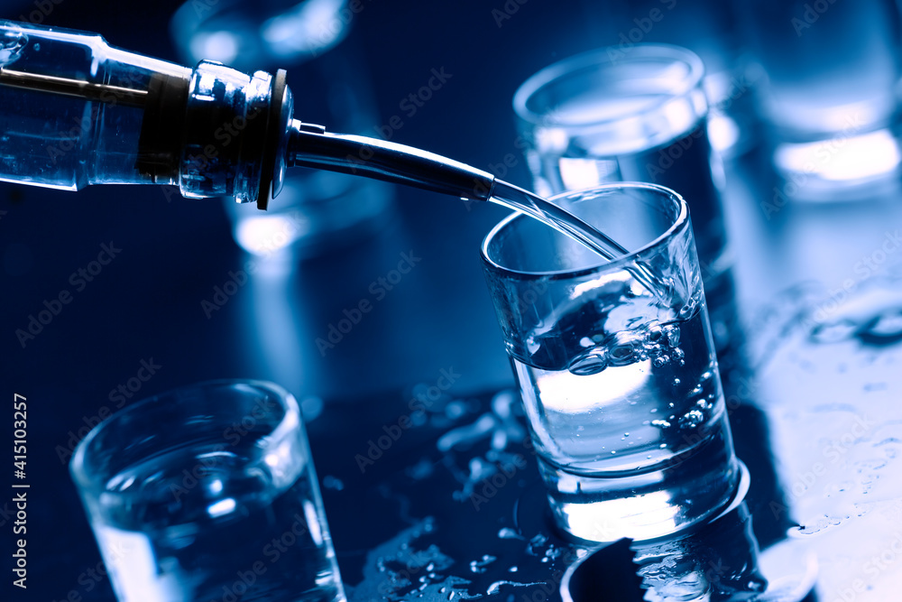 Russian vodka pouring from the bottle into glass in a bar.Copy space. close up Russian vodka pouring from the bottle into glass in a bar.Copy space. close up