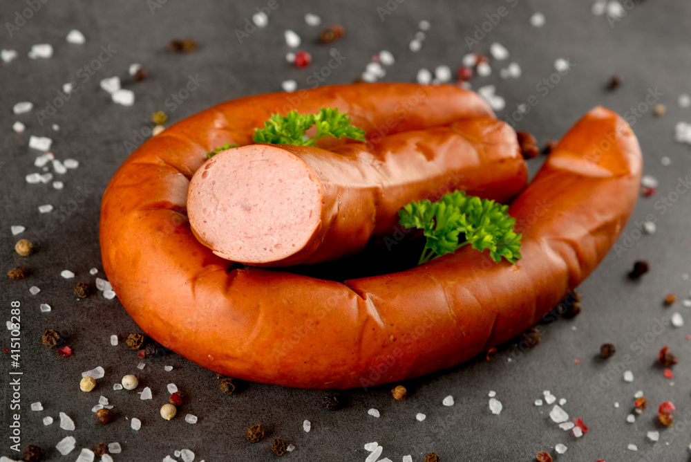 Fresh polish sausages, pepper and lettuce. Meat composition taken on dark stone with reflection. Fresh polish sausages, pepper and lettuce. Meat composition taken on dark stone with reflection.