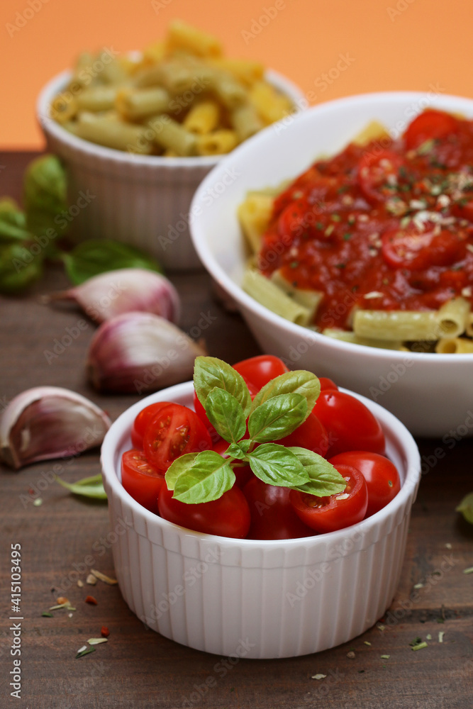 Bowl with tiny tomatoes decorated with basil leaves Bowl with tiny tomatoes decorated with basil leaves