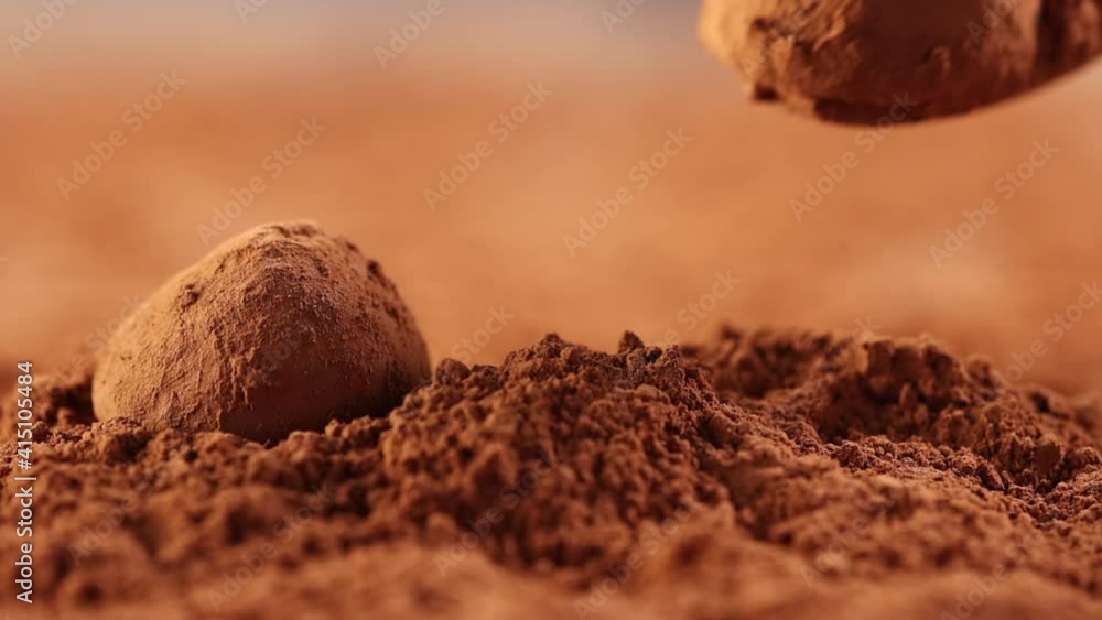 chocolate truffle is poured into cocoa powder with a spoon close - up slow motion chocolate truffle is poured into cocoa powder with a spoon close - up slow motion