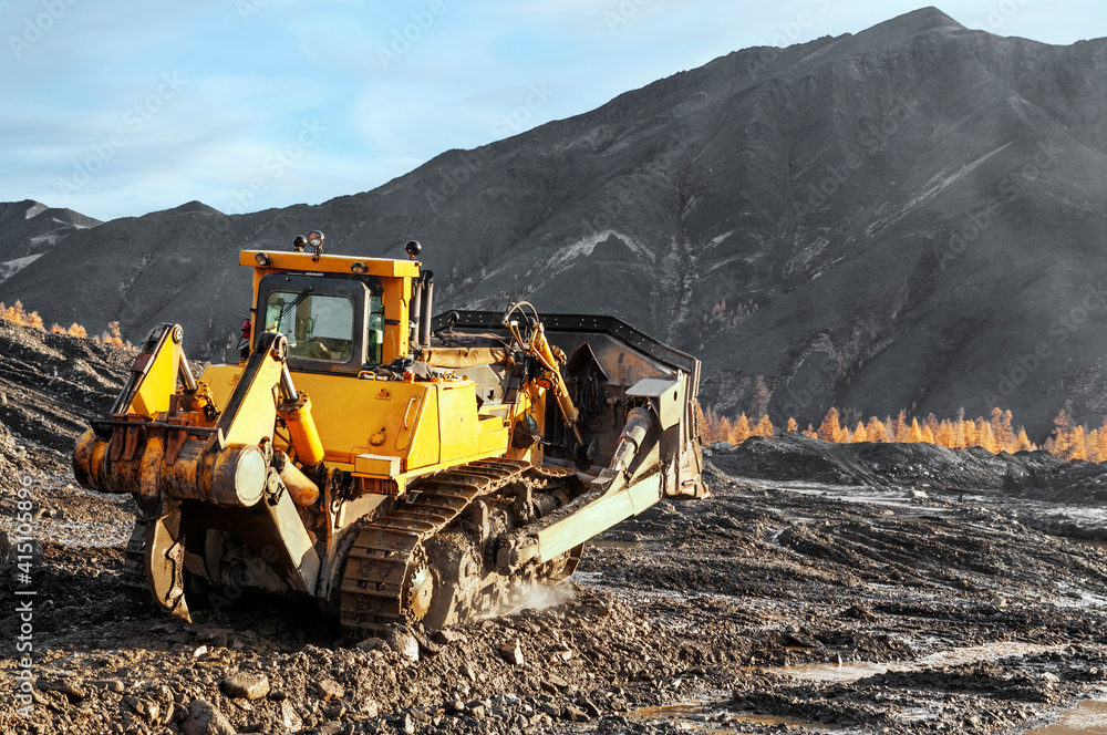 Bulldozer in process of working in an industrial mountain area Bulldozer in process of working in an industrial mountain area